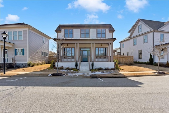 view of front of property featuring a porch and fence