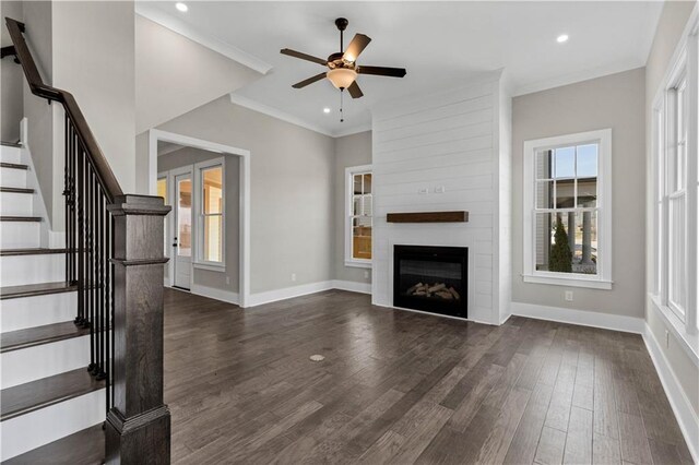 unfurnished living room with a wealth of natural light, baseboards, and dark wood-style flooring