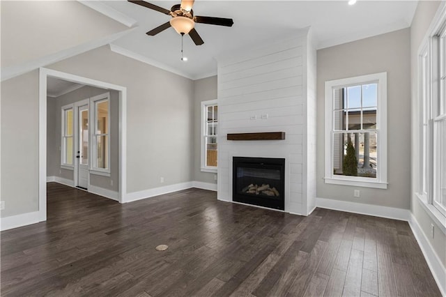 unfurnished living room with a large fireplace, baseboards, dark wood-type flooring, and ornamental molding