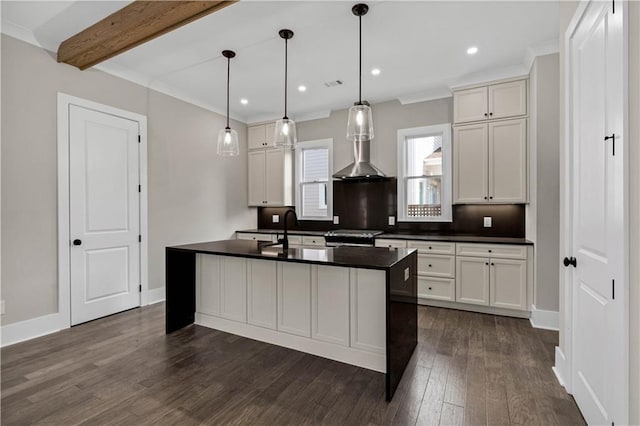 kitchen with dark countertops, dark wood-type flooring, a sink, beamed ceiling, and baseboards