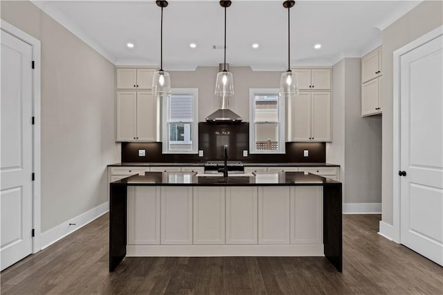 kitchen featuring dark countertops, white cabinetry, and a kitchen island with sink