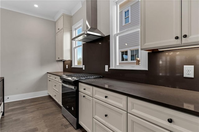 kitchen with tasteful backsplash, baseboards, dark countertops, ventilation hood, and gas stove