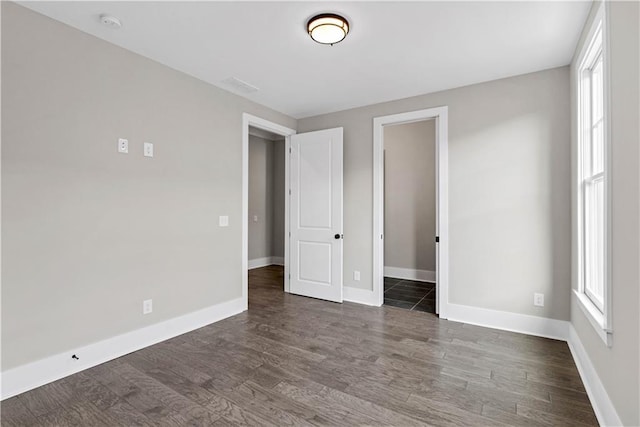 spare room featuring wood finished floors and baseboards