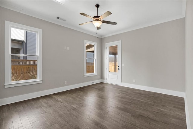 unfurnished room featuring visible vents, baseboards, a ceiling fan, dark wood-style flooring, and crown molding