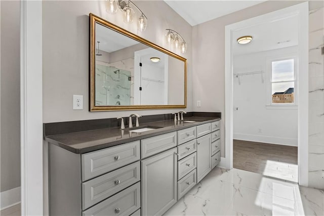 bathroom with marble finish floor, double vanity, a sink, and a marble finish shower