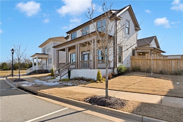 view of front of home with covered porch and fence