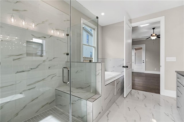 bathroom with marble finish floor, a marble finish shower, vanity, baseboards, and a bath