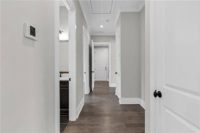 hall featuring attic access, baseboards, and dark wood-style floors