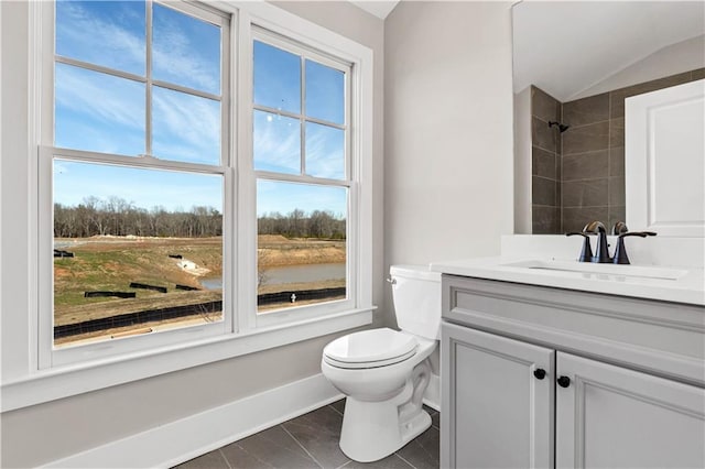 bathroom featuring baseboards, a shower, toilet, vaulted ceiling, and vanity