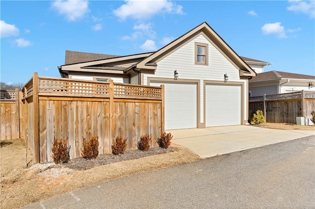 view of front of home with a garage, fence, and concrete driveway