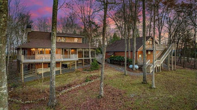 back house at dusk featuring a deck