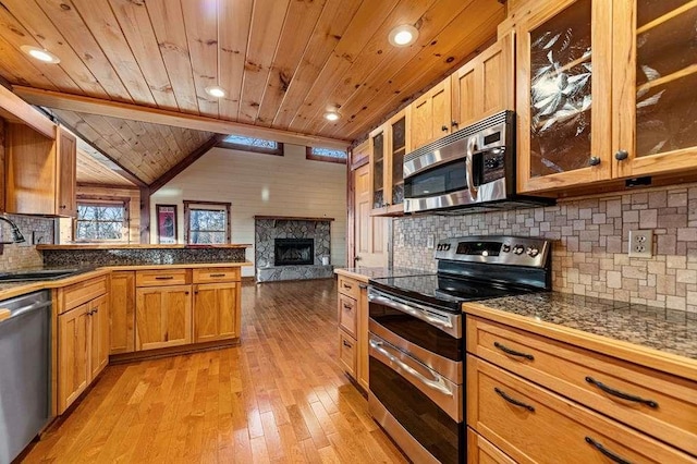 kitchen featuring wooden ceiling, a stone fireplace, sink, light hardwood / wood-style floors, and stainless steel appliances