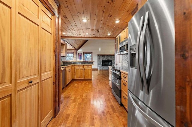 kitchen with lofted ceiling, light hardwood / wood-style floors, kitchen peninsula, stainless steel appliances, and wood ceiling