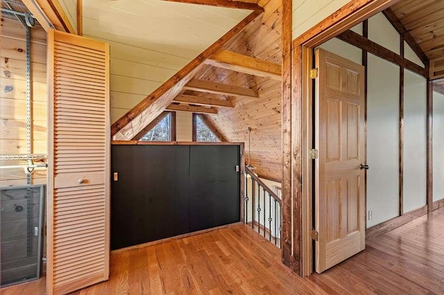 interior space featuring hardwood / wood-style floors, lofted ceiling with beams, wooden ceiling, and wooden walls