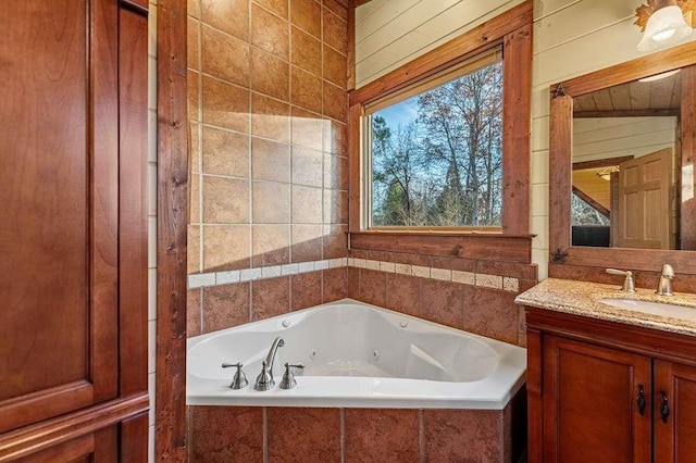 bathroom with vanity, a relaxing tiled tub, and wooden walls