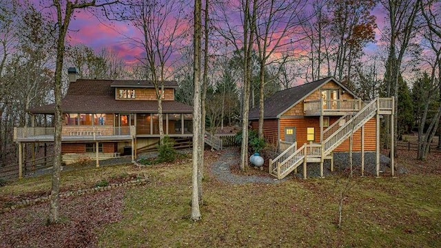 back house at dusk with a wooden deck