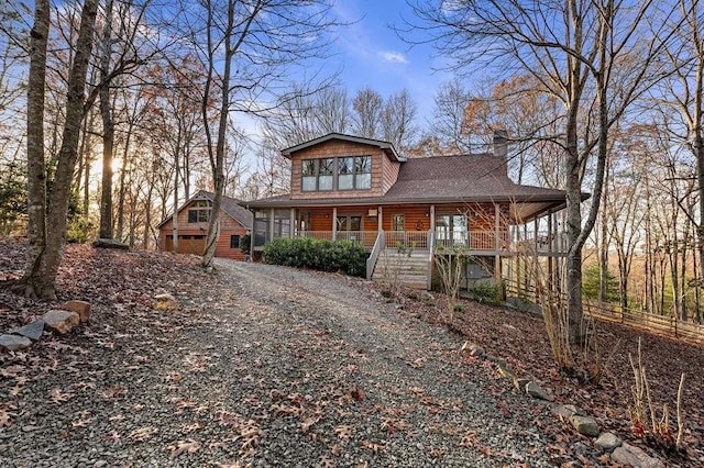 view of front of house featuring a porch, a garage, and an outdoor structure