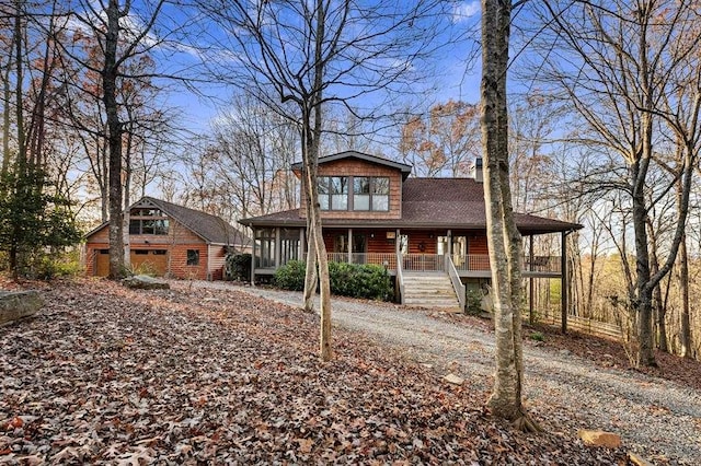 back of house featuring an outbuilding, covered porch, and a garage