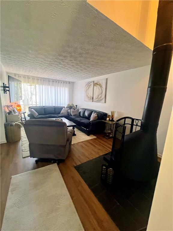 living area with wood finished floors and a textured ceiling