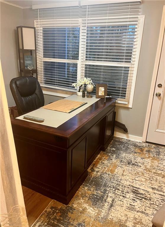 home office with baseboards and wood finished floors