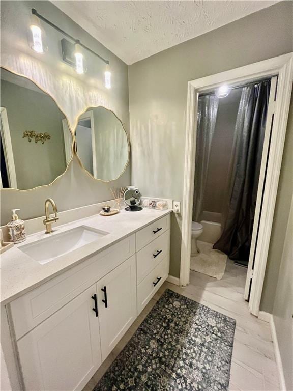 full bath featuring toilet, a textured ceiling, vanity, and baseboards