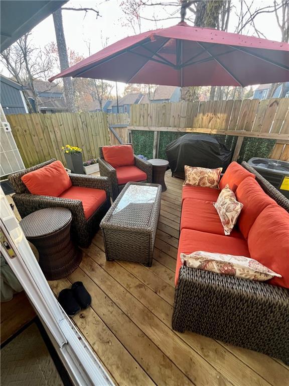 wooden deck featuring an outdoor hangout area, a grill, and fence