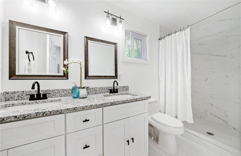 bathroom featuring walk in shower, toilet, and vanity