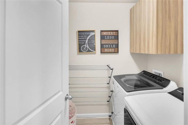 104 Auburn Crossing Way, Auburn, GA 30011 - laundry room featuring separate washer and dryer, cabinet space, baseboards, and light wood-type flooring