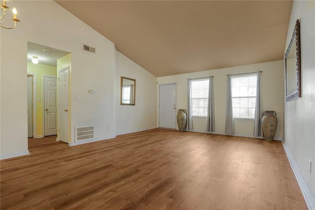 unfurnished room with baseboards, a notable chandelier, visible vents, and wood finished floors