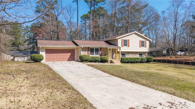 split level home with a front yard, brick siding, a garage, and driveway