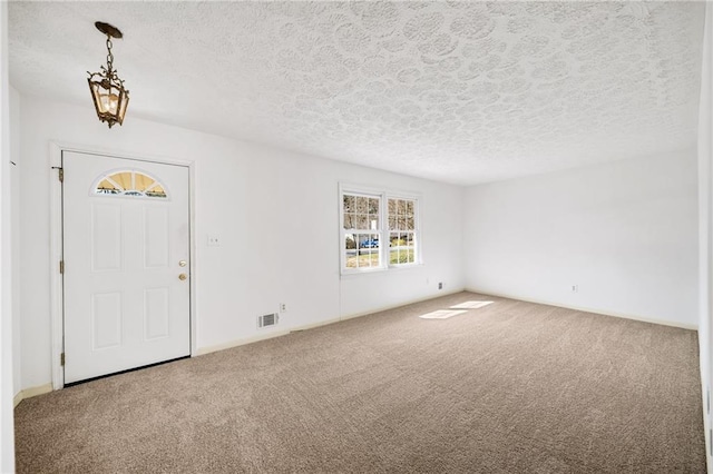 carpeted entryway with visible vents and a textured ceiling