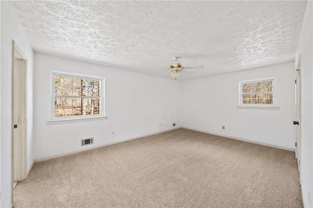 unfurnished bedroom with visible vents, carpet flooring, a textured ceiling, and a ceiling fan