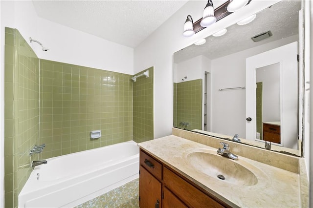 full bath featuring visible vents, vanity, a textured ceiling, and shower / tub combination