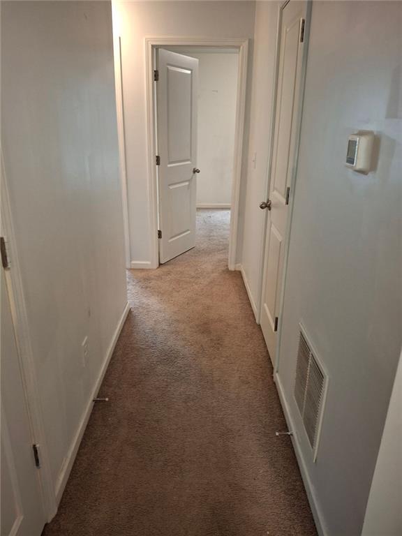 corridor featuring light colored carpet