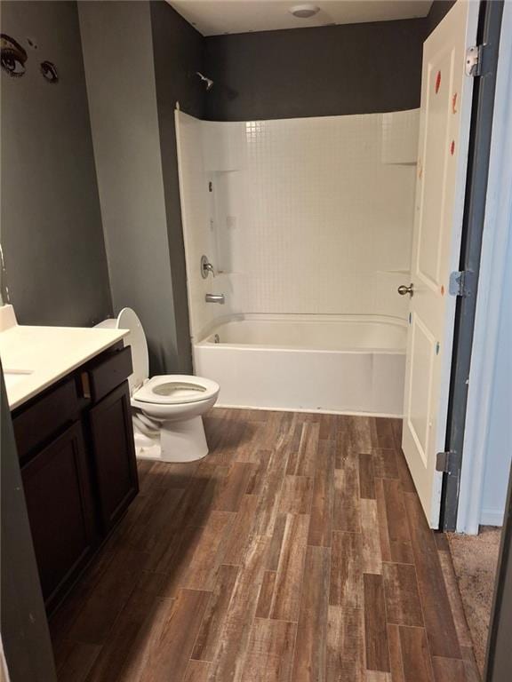 full bathroom featuring vanity, bathtub / shower combination, hardwood / wood-style floors, and toilet