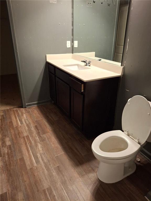 bathroom featuring vanity, hardwood / wood-style flooring, and toilet