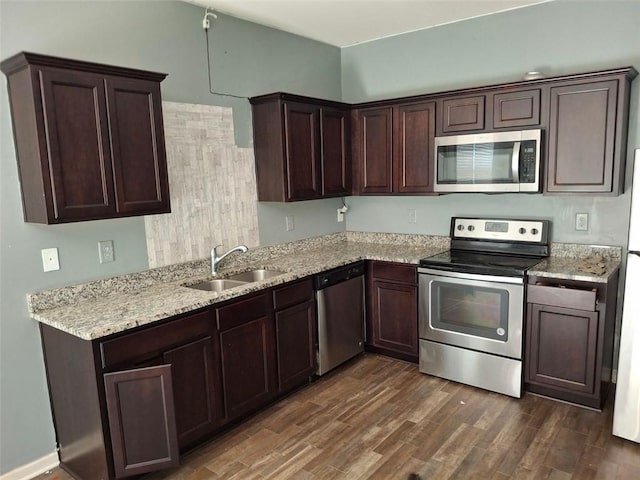 kitchen featuring appliances with stainless steel finishes, sink, dark brown cabinetry, light stone counters, and dark hardwood / wood-style floors