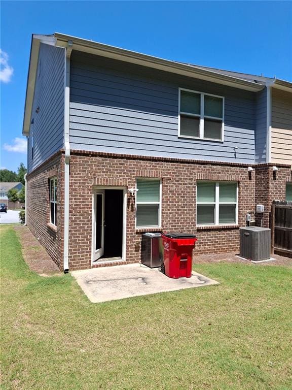 rear view of property with a patio area, a lawn, and central AC unit