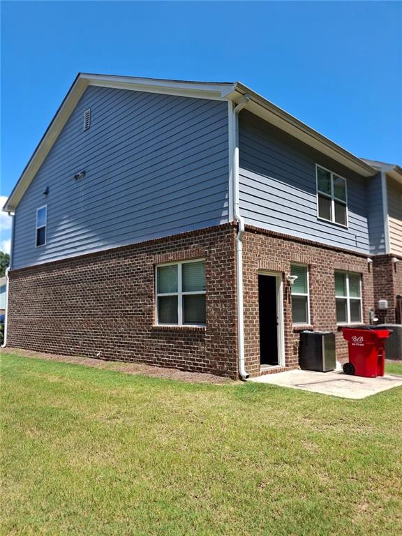 back of house with a patio and a lawn