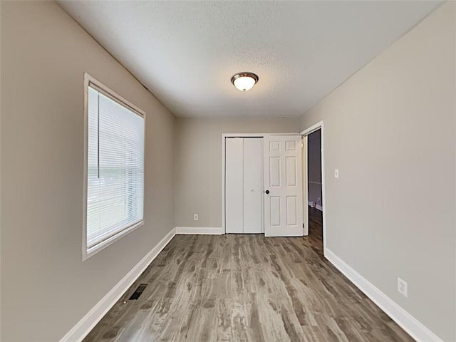 908 Kennesaw Dr, Forest Park, GA 30297 - unfurnished bedroom featuring baseboards, wood finished floors, a closet, and a textured ceiling