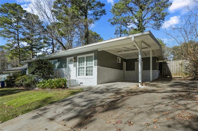 view of front facade with driveway, an attached carport, and brick siding