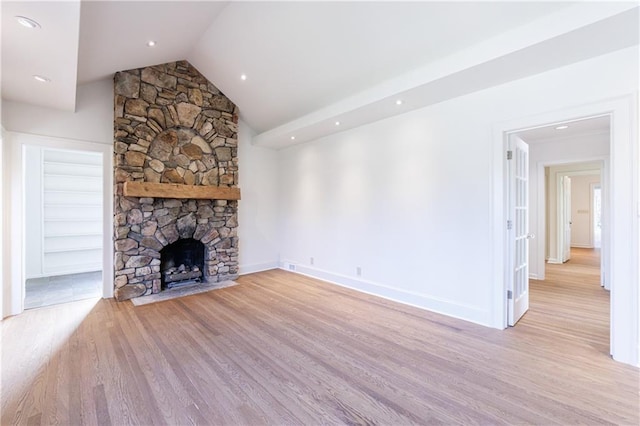 unfurnished living room featuring lofted ceiling, light wood-type flooring, and a fireplace