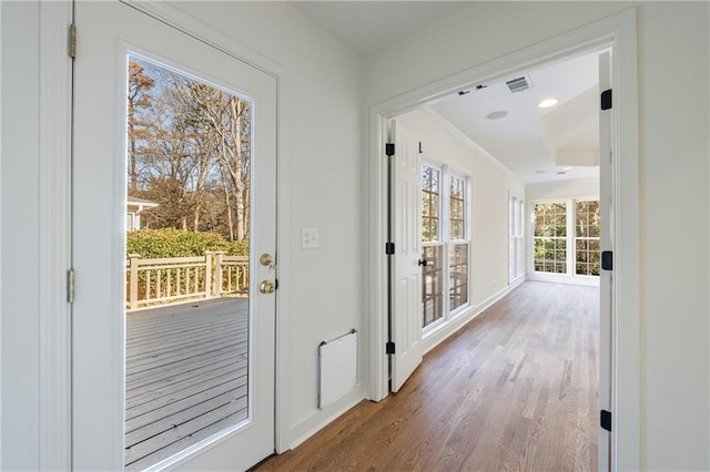 doorway to outside with hardwood / wood-style floors and ornamental molding