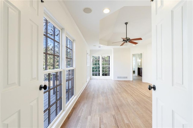 interior space featuring a fireplace, a tray ceiling, and ceiling fan