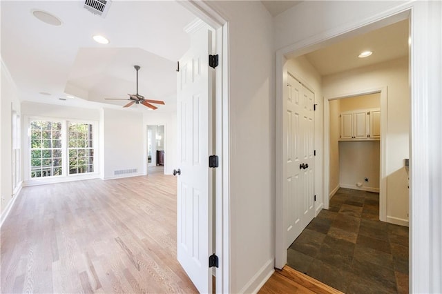 hall featuring a raised ceiling and light wood-type flooring