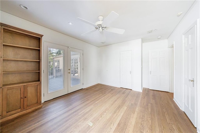 empty room featuring french doors, light wood-type flooring, and ceiling fan