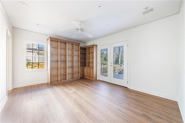 spare room with ceiling fan, light wood-type flooring, and french doors