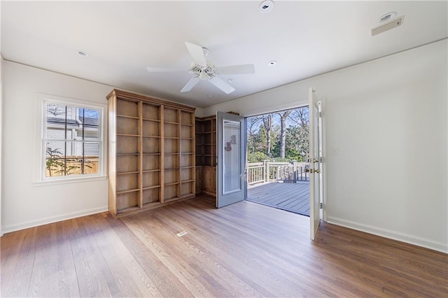 spare room featuring ceiling fan, plenty of natural light, and hardwood / wood-style flooring