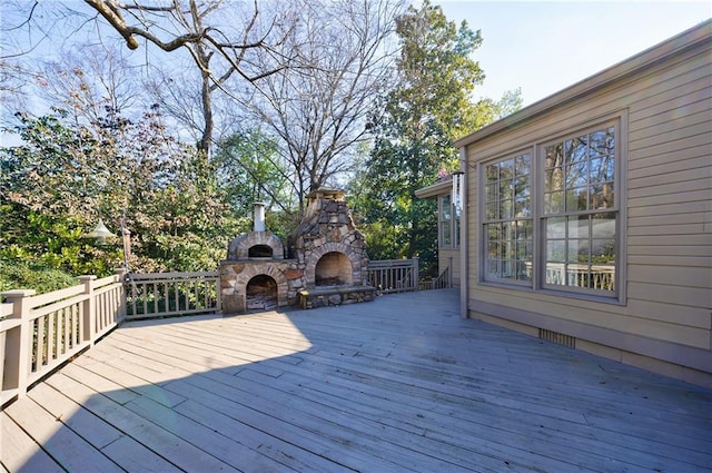 deck with an outdoor stone fireplace