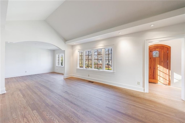 spare room featuring light hardwood / wood-style flooring and vaulted ceiling